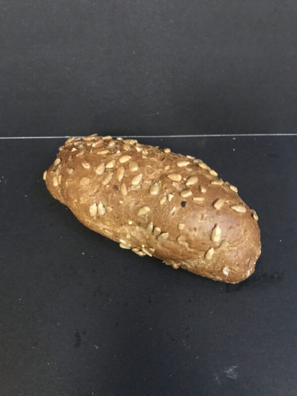 Harde bruine bol met zonnebloempitten (bruin krokant kleinbrood gedecoreerd met zonnebloempitten)
