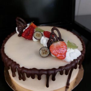 Luxe kerst slagroomtaart met sinaasappelcompote en chocoladebiscuit gedecoreerd met chocoladerepen
