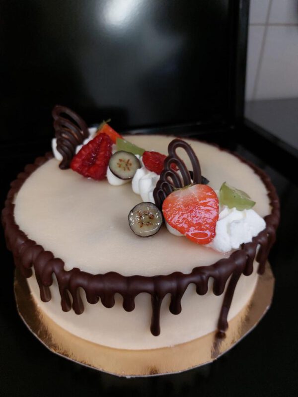 Luxe kerst slagroomtaart met sinaasappelcompote en chocoladebiscuit gedecoreerd met chocoladerepen